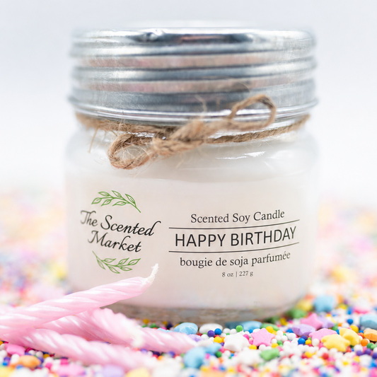 Scented soy candle labeled 'Happy Birthday' from The Scented Market on a colorful background.
